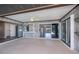 Covered outdoor patio boasts wood paneling, ceiling fan, and sliding glass doors with views of the pool at 552 Bellaire Dr, Venice, FL 34293