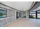 Covered outdoor patio has wood paneling, ceiling fan, and sliding glass doors with views of the pool at 552 Bellaire Dr, Venice, FL 34293