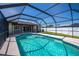 Sparkling pool is surrounded by a screened enclosure and white fencing at 552 Bellaire Dr, Venice, FL 34293