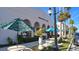 Picturesque outdoor seating area with tables, umbrellas, and lush landscaping at 552 Bellaire Dr, Venice, FL 34293