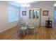 Inviting dining area with light-filled windows, hardwood floors, and a classic glass table at 554 Aspen Ave, Venice, FL 34285
