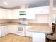 Well-lit kitchen with white appliances, ample counter space and breakfast bar seating for two at 554 Aspen Ave, Venice, FL 34285
