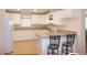 Bright kitchen with white cabinets, laminate countertops and bar seating at the breakfast counter at 554 Aspen Ave, Venice, FL 34285