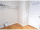 Unassuming laundry room featuring wire shelving, utility hookups, and wood flooring at 554 Aspen Ave, Venice, FL 34285