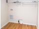 Simple laundry room with wire shelving, utility hookups, and wood flooring at 554 Aspen Ave, Venice, FL 34285