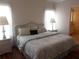 Comfortable main bedroom featuring a king bed, hardwood floors, and bedside tables at 554 Aspen Ave, Venice, FL 34285