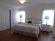 Cozy main bedroom with a king bed, hardwood floors, and natural light at 554 Aspen Ave, Venice, FL 34285