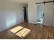 Bright bedroom showcasing modern barn door leading to bathroom; features sleek, wood-look flooring at 56 Lakeview Dr, North Port, FL 34287