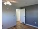Bedroom featuring wood-look flooring, ceiling fan, and a gray accent wall at 56 Lakeview Dr, North Port, FL 34287