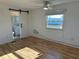 Well-lit bedroom with wood-look flooring, barn door to bathroom, and comfortable living space at 56 Lakeview Dr, North Port, FL 34287