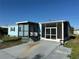 Charming blue home featuring a screened-in porch and a welcoming front entrance at 56 Lakeview Dr, North Port, FL 34287