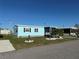 Exterior view of a cozy blue house, complemented by a well-maintained lawn at 56 Lakeview Dr, North Port, FL 34287