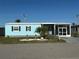 A beautiful blue house is enhanced by lush landscaping and a welcoming entrance at 56 Lakeview Dr, North Port, FL 34287