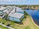 Aerial view features lakeside condos, lush landscaping, sidewalks, and mature palm trees at 5739 Sabal Trace Dr # 102, North Port, FL 34287