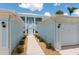 Inviting exterior featuring an upper level entrance with white stairs, nestled between the garage entrances at 5739 Sabal Trace Dr # 102, North Port, FL 34287