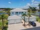 Bright blue two-story condo with white trim, three garage doors, and lush palm trees on a sunny day at 5739 Sabal Trace Dr # 102, North Port, FL 34287