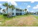 Exterior lake view features a two-story blue building with a screened lanai and lush landscaping at 5739 Sabal Trace Dr # 102, North Port, FL 34287