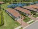 Birds-eye view of homes with well-manicured lawns, tiled roofs, and beautiful community landscaping at 5853 Semolino St, Nokomis, FL 34275