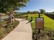 Well-maintained community Bark Park with lush grass, mature trees, and clear signage for residents and pets at 5853 Semolino St, Nokomis, FL 34275