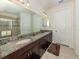 Bathroom featuring dual sinks, granite countertops, and tiled shower with glass door at 5853 Semolino St, Nokomis, FL 34275
