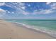 Expansive view of the beach and tranquil ocean, with gentle waves meeting the shoreline at 5853 Semolino St, Nokomis, FL 34275