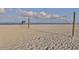Sandy beach with volleyball net, clear blue water, and a lifeguard station on the horizon at 5853 Semolino St, Nokomis, FL 34275