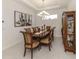 Formal dining area featuring a chandelier, seating for eight, and decorative wall art at 5853 Semolino St, Nokomis, FL 34275