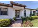 Charming front entrance with a brick walkway, decorative glass door, and manicured landscaping at 5853 Semolino St, Nokomis, FL 34275