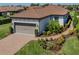 Well-maintained home with a two-car garage, beautiful landscaping, and a brick driveway at 5853 Semolino St, Nokomis, FL 34275