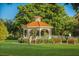 Charming gazebo with a red tile roof, surrounded by lush greenery, offering a serene outdoor space at 5853 Semolino St, Nokomis, FL 34275