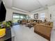 Spacious living room with plush sofas and view of screened lanai and backyard at 5853 Semolino St, Nokomis, FL 34275