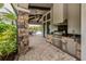 Outdoor kitchen with built-in grill, granite countertops, and a view of the pool at 5853 Semolino St, Nokomis, FL 34275