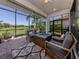 Relaxing screened-in patio features stylish seating, a fire pit table, and a scenic lake view at 5853 Semolino St, Nokomis, FL 34275