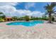 Community pool featuring palm trees, lounge chairs, and orange shade structures, creating a resort-like atmosphere at 5853 Semolino St, Nokomis, FL 34275