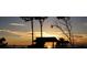 Scenic sunset view over the water with silhouetted trees and beach huts, ideal for evening relaxation at 5853 Semolino St, Nokomis, FL 34275