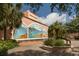 Exterior view of the Venice Theater featuring a mural, lush landscaping, and clear blue skies at 5853 Semolino St, Nokomis, FL 34275
