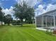 View of back yard featuring a pool, screened-in enclosure, and trees behind home at 5966 Willows Bridge Loop, Ellenton, FL 34222