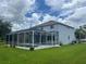 View of backyard featuring a screened-in porch, a pool, and a well-manicured lawn at 5966 Willows Bridge Loop, Ellenton, FL 34222