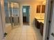 En suite bathroom with double vanity sinks, tiled floors, and separate glass shower at 5966 Willows Bridge Loop, Ellenton, FL 34222