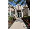Clubhouse entrance with white columns and lush landscaping, enhanced by red geraniums at 5966 Willows Bridge Loop, Ellenton, FL 34222