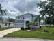 Two-story home featuring a well-manicured lawn, landscaping, attached garage, and covered entrance at 5966 Willows Bridge Loop, Ellenton, FL 34222