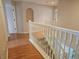Hallway with white banister, wood floors, and access to rooms at 5966 Willows Bridge Loop, Ellenton, FL 34222