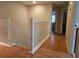 Hallway featuring wood floors, white banister, and access to rooms at 5966 Willows Bridge Loop, Ellenton, FL 34222