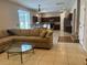 Open-concept living room with tile floors seamlessly connects to the kitchen and dining area at 5966 Willows Bridge Loop, Ellenton, FL 34222
