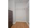 Spacious walk-in closet with hardwood flooring, white shelving, and dresser at 5966 Willows Bridge Loop, Ellenton, FL 34222