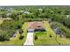 Aerial view of a home with a lush landscape, driveway, and surrounding trees at 6199 Stamp St, Port Charlotte, FL 33981