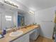 Bathroom with dual sinks, vanity and a large mirror with updated lighting fixtures at 6199 Stamp St, Port Charlotte, FL 33981