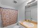 Bathroom with tiled shower, decorative curtain, and vanity sink at 6199 Stamp St, Port Charlotte, FL 33981