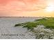 Picturesque beach scene with soft sand, gentle waves, and a stunning sunset over the horizon at Manasota Key at 6199 Stamp St, Port Charlotte, FL 33981