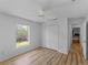 A bright bedroom features light hardwood floors, closet, and a window view at 6199 Stamp St, Port Charlotte, FL 33981